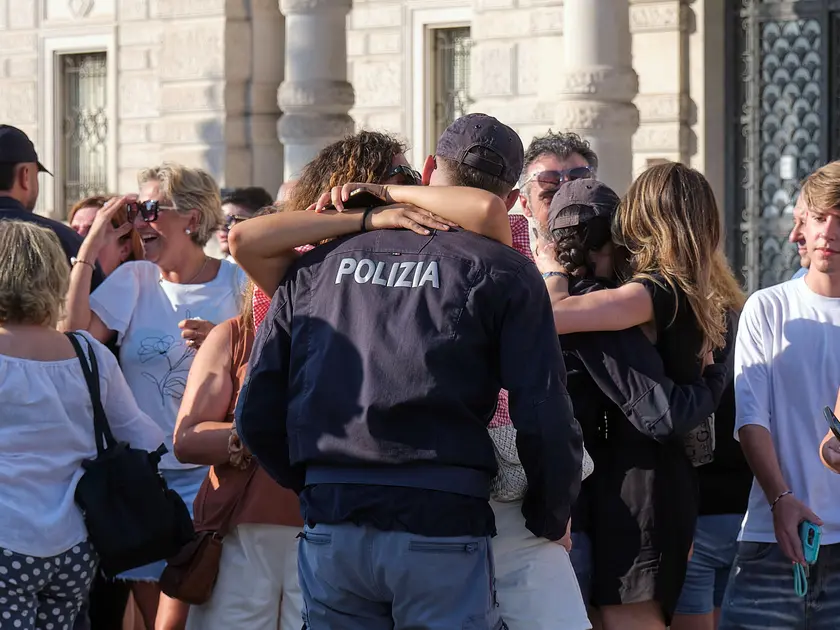L'abbraccio dei nuovi agenti di Polizia con le famiglie alla fine della cerimonia dell'ammainabandiera. Foto Silvano