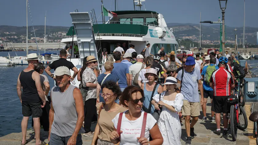 Turisti a Muggia vicino all’imbarco del Delfino Verde Foto Andrea Lasorte