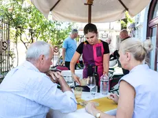 Una cameriera serve i clienti al ristorante Rosenbar. Foto Tibaldi