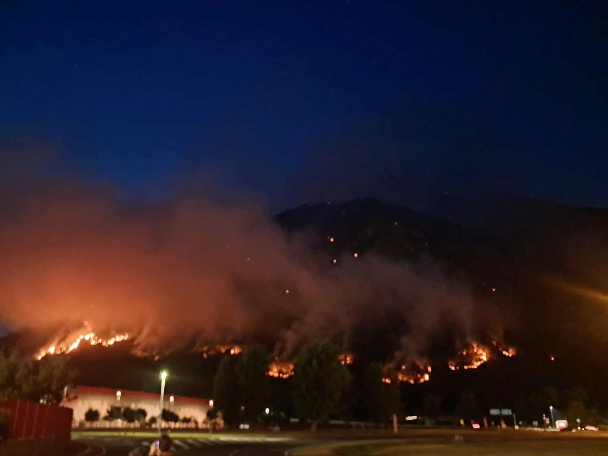 Le colonne di fumo degli incendi che stanno bruciando in Carnia sono visibili a chilometri di distanza e in alcune zone l’aria è diventata difficile da respirare. Una coltre grigia avvolge vallate e montagne, oscurando il cielo e cambiando il volto del paesaggio. Nella notte appena trascorsa, nel buio erano le fiamme sui versanti a illuminare la montagna, mentre con il giorno il fumo è tornato a dominare lo scenario.