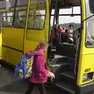 Una studentessa sale a bordo di uno scuolabus per andare a lezione Foto d’archivio