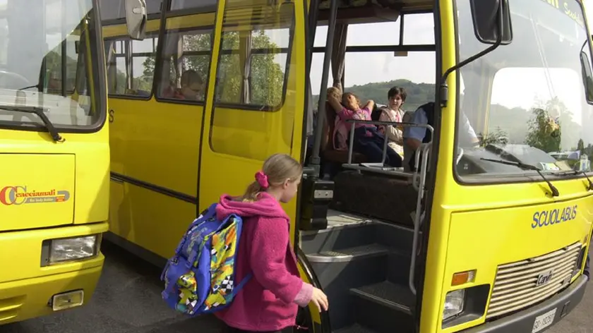 Una studentessa sale a bordo di uno scuolabus per andare a lezione Foto d’archivio