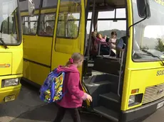 Una studentessa sale a bordo di uno scuolabus per andare a lezione Foto d’archivio