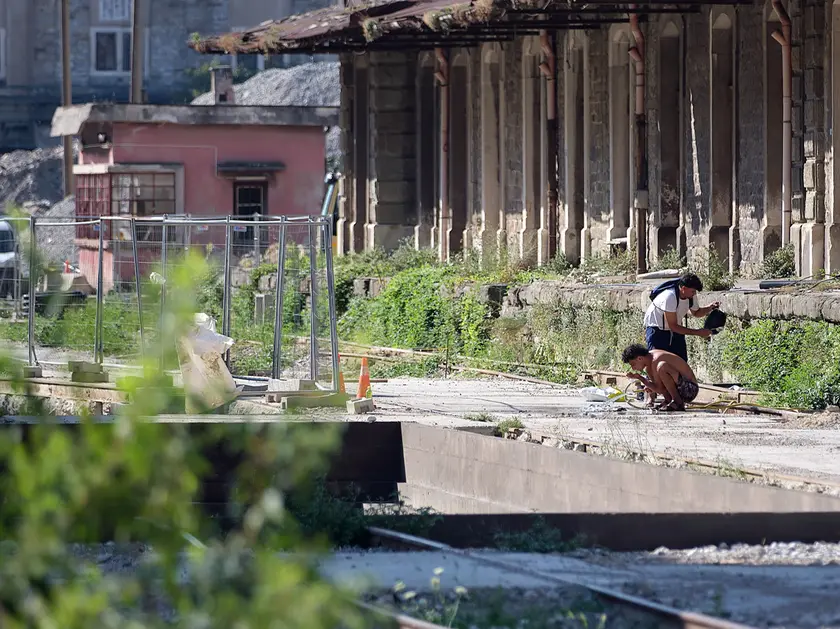 Alcuni migranti tra i cantieri del Porto Vecchio (foto Massimo Silvano)