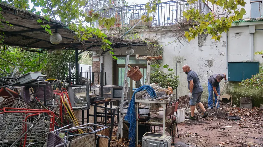 Una squadra di operai al lavoro già da giorni per sgomberare il cortile attiguo al ristorane la Marinella da vecchi arredi abbandonati lì ormai da anni. Foto Massimo Silvano