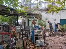 Una squadra di operai al lavoro già da giorni per sgomberare il cortile attiguo al ristorane la Marinella da vecchi arredi abbandonati lì ormai da anni. Foto Massimo Silvano