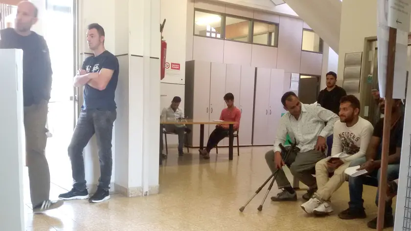 Cittadini stranieri in attesa di accedere agli sportelli dell’Anagrafe in Municipio