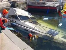 Le operazioni dei vigili del fuoco per riportare a galla il motoscafo semi-affondato in riva San Vito a Grado