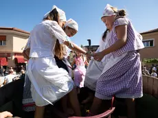 Alcune bambine pigiano l'uva alla Festa dell'uva di Staranzano