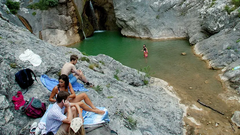 Alcuni ragazzi fanno il bagno nelle pozze del torrente Rosandra