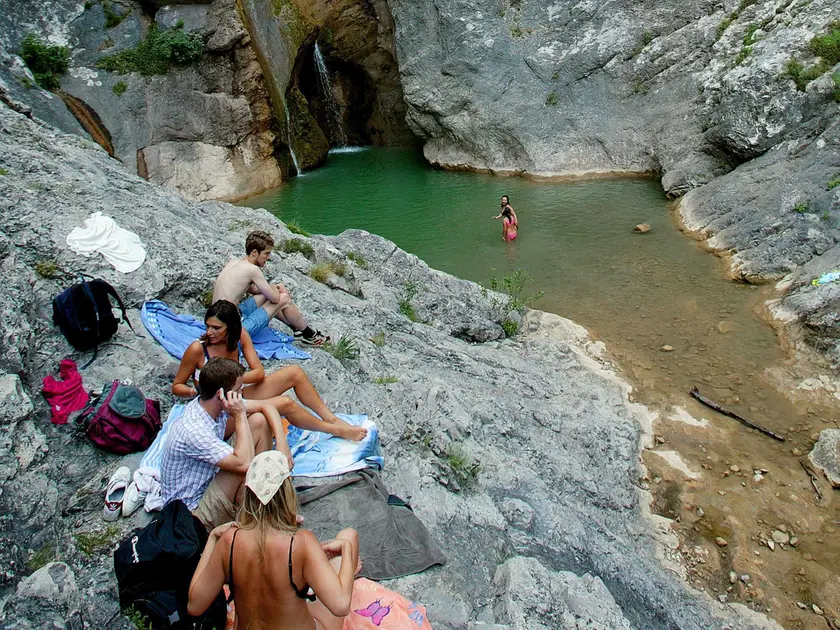 Alcuni ragazzi fanno il bagno nelle pozze del torrente Rosandra