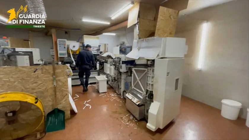 La Guardia di Finanza all’interno della fabbrica clandestina di bionde smantellata a Gonars