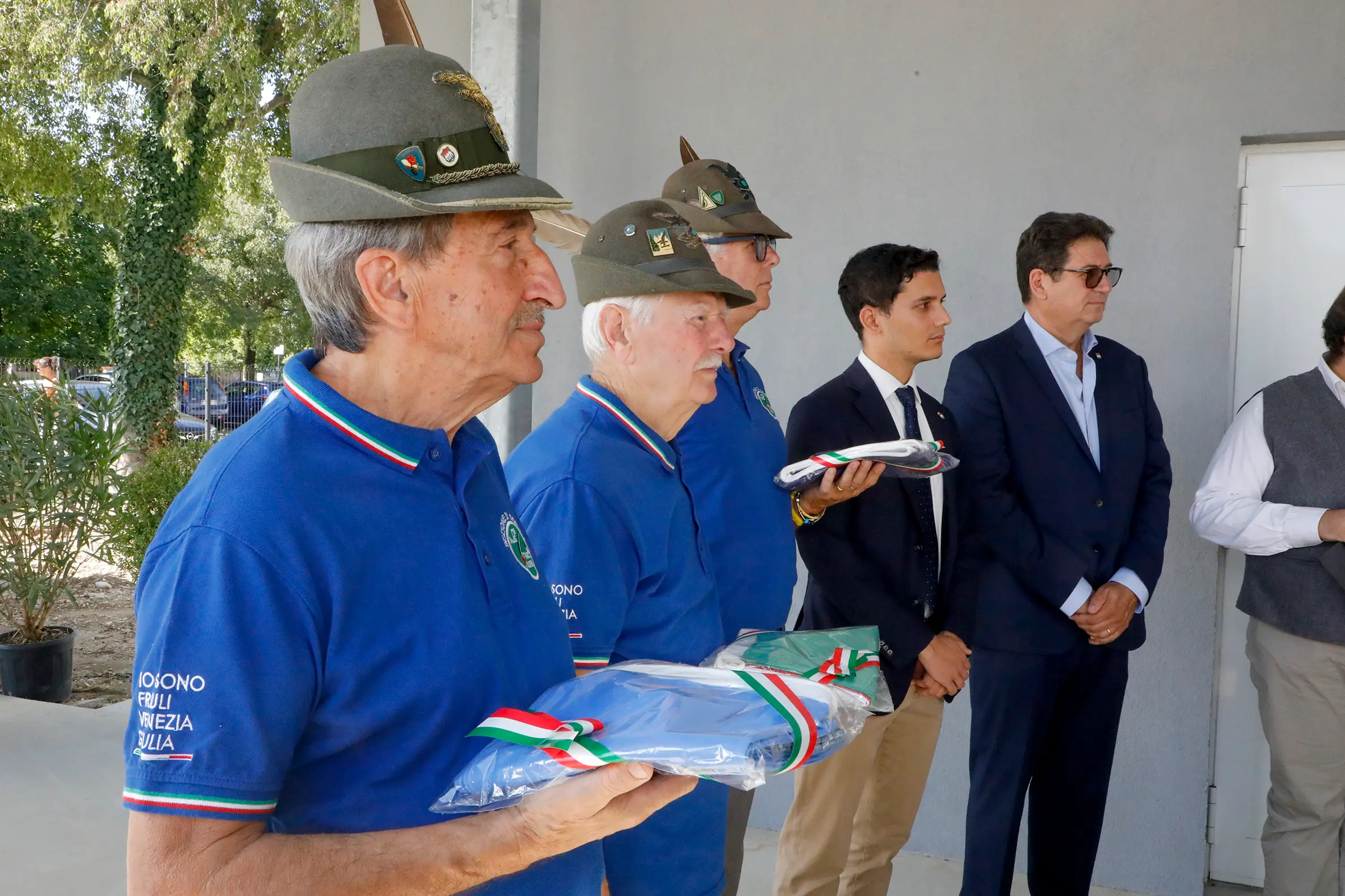 Gli alpini consegnano le bandiere italiana, dell'Unione europea e della Regione alla scuola. Foto Katia Bonaventura