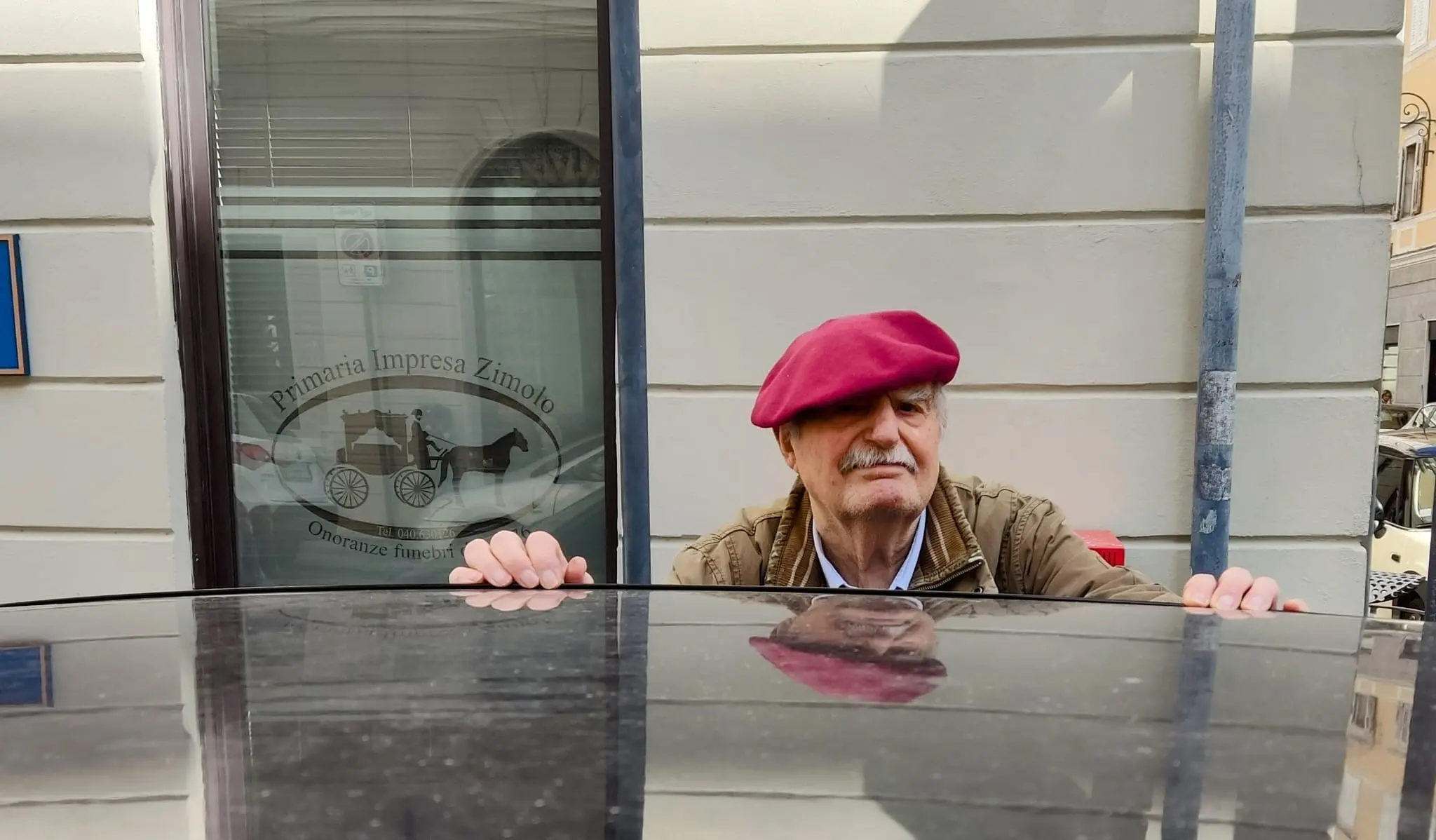 Pierri "posa" ironicamente davanti alla vetrina di un'impresa di onoranze funebri a Trieste