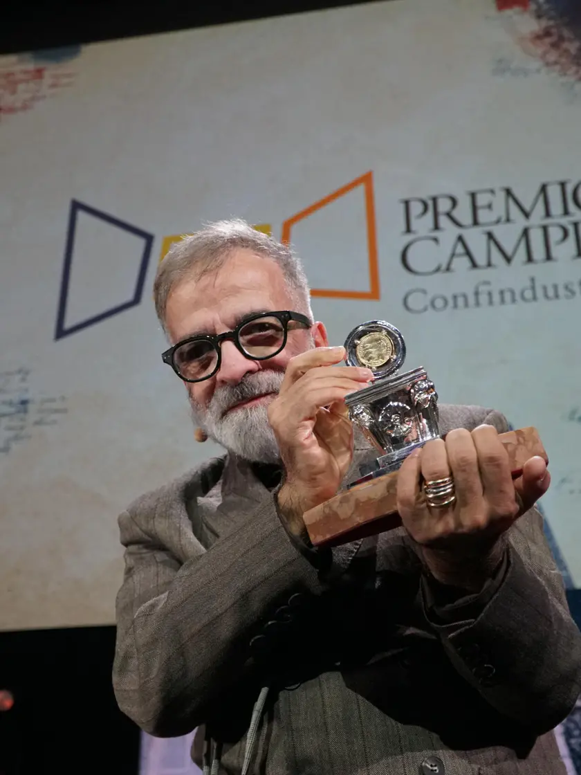 Lo scrittore Marcello Fois, vincitore della 64° edizione del Premio Letterario Campiello con “L’Immensa distrazione” (Einaudi) posa sul palco reggendo con le mani l’ambito premio, al termine della cerimonia finale, nella sala grande del Palazzo del Cinema del Lido, Venezia 3 ottobre 2026. ANSA/ANDREA MEROLA ------ Writer Marcello Fois, winner of the 64th edition of the Campiello Literary Prize for *L’Immensa distrazione* (Einaudi), poses on stage holding the coveted award at the end of the final ceremony in the main hall of the Palazzo del Cinema at the Lido, Venice, October 3, 2026. ANSA/ANDREA MEROLA