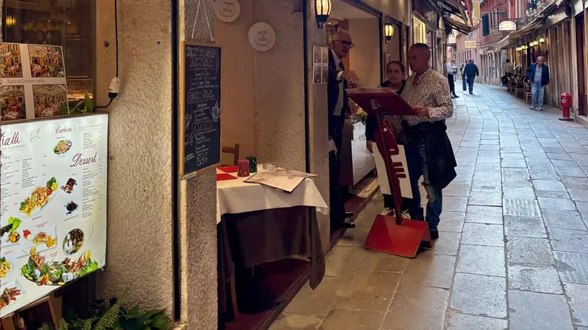 Turisti fuori dai ristoranti del centro storico di Venezia
