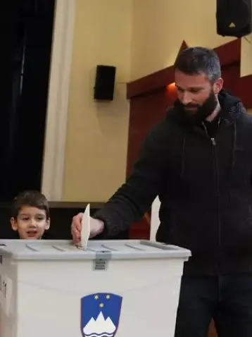 Un cittadino sloveno al voto l’11 ottobre (foto Ansa/Epa)