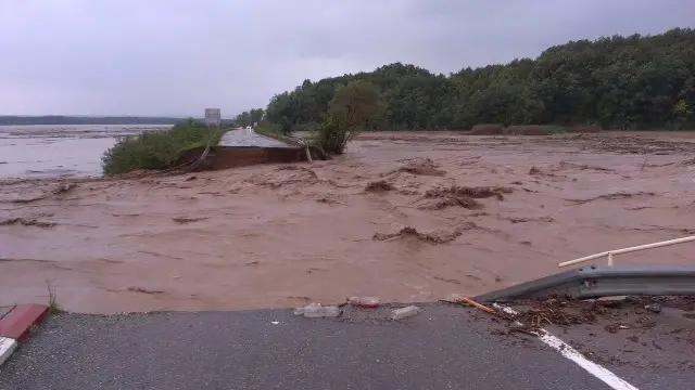 Una strada spezzata in due da un fiume di fango