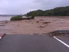 Una strada spezzata in due da un fiume di fango