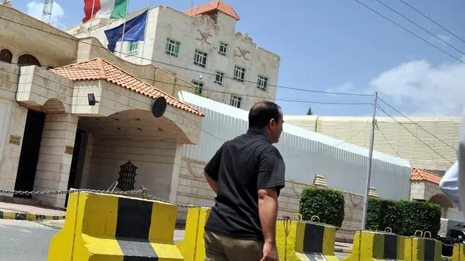 epa03325917 A Yemeni man passes the Italian embassy a day after an Italian officer was kidnapped in Sana'a, Yemen, 30 July 2012. According to media reports, an Italian officer was kidnapped on 29 July in front of the Italian embassy in the Yemeni capital Sana'a by armed men. The man was responsible for security issues at the embassy. EPA/YAHYA ARHAB