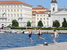 Tre ragazzi si lanciano dal molo Audace (fotoservizio di Andrea Lasorte)