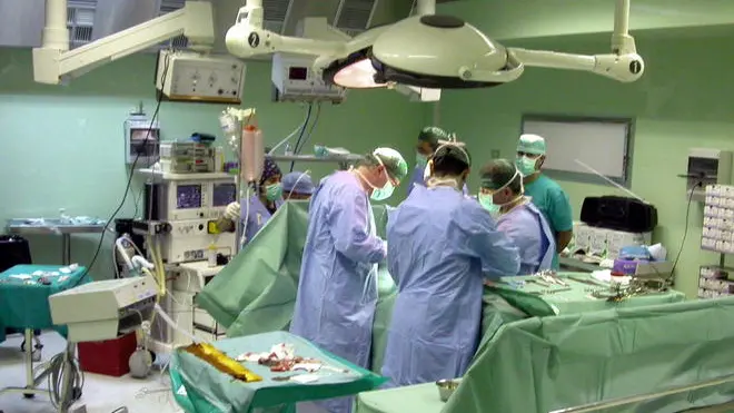 ROMA 200702212007091820070919 20070220 - ROMA - CRO - SANITA': IMPIANTATI IN TRE PAZIENTI ORGANI DI SIEROPOSITIVO. Una equipe medica al lavoro in sala operatoria, in una immagine del 02 marzo 2004. Gli organi espiantati da una donna di 41 anni, sieropositiva, sono stati impiantati su tre pazienti toscani. Un errore umano, all'origine dell'incidente giudicato dai sanitari ''un evento estremamente grave'', avvenuto all'ospedale fiorentino di Careggi. A rendere noto il fatto, a poche ore dall'emergere dell'errore, sono stati il direttore dell'Organizzazione toscana trapianti, Franco Filipponi, e il direttore sanitario dell'Azienda Ospedaliero Universitaria di Careggi Mauro Marabini. ANSA/ARCHIVIO - MARIO ROSAS - DRN - Una e'quipe esegue un trapianto e l'ospedale Careggi di Firenze dove si e' verificato l'errore Una sala operatoria (MARIO ROSAS/ARCHIVIO/ )