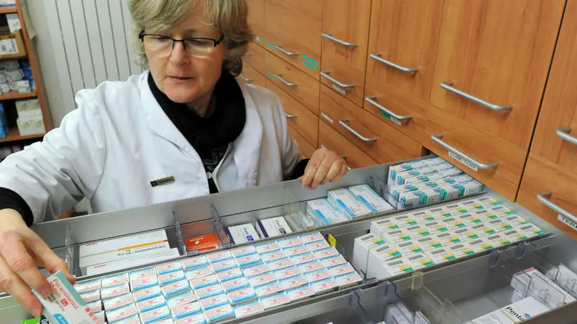 Una farmacista tra gli scaffali dei medicinali