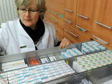 Una farmacista tra gli scaffali dei medicinali