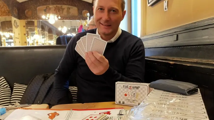 Adriano Zurini tiene in mano le carte del gioco “Five Champ” da lui inventato