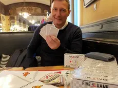 Adriano Zurini tiene in mano le carte del gioco “Five Champ” da lui inventato