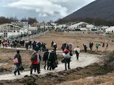 Migrants walk back to the Lipa camp outside Bihac, Bosnia, Wednesday, Dec. 30, 2020, after hundreds failed to be relocated from the burnt-out tent camp in the northwest of the country. The migrants were supposed on Tuesday to be transferred from the much-criticized Lipa camp to a new location in the central part of the country, but have instead spent some 24 hours in buses before being told on Wednesday afternoon to disembark and return to the now empty camp site. (AP Photo/Kemal Softic)