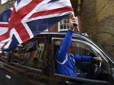 Un tassista londinese sventola la bandiera della Gran Bretagna dopo la vittoria della Brexit