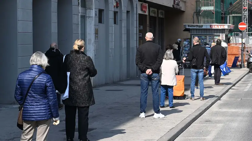 Persone in coda a Trieste per fare la spesa