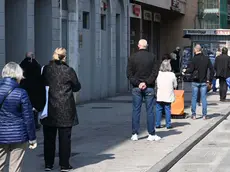 Persone in coda a Trieste per fare la spesa