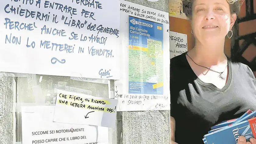 La libraia Gabriella Cosetti accanto ai cartelli in vetrina