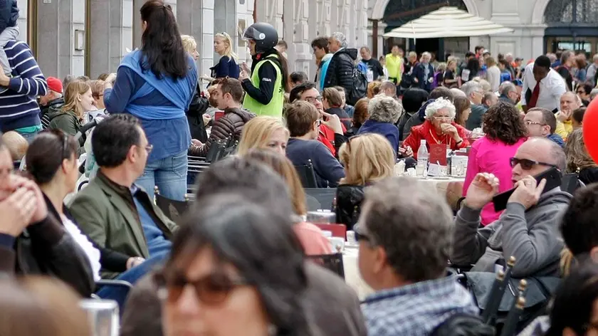 Clienti ai tavolini del Caffè degli specchi in piazza Unità