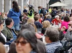 Clienti ai tavolini del Caffè degli specchi in piazza Unità