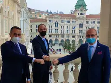 Da sinistra i ministri degli Esteri di Italia (Luigi Di Maio), Slovenia (Anže Logar) e Croazia (Gordan Grlić Radman) al summit del 19 dicembre a Trieste. In questa foto di Francesco Bruni si danno la mano, Covid permettendo, davanti alla Prefettura in piazza Unità