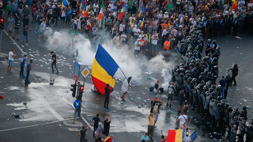 Protesters stand in front of police during a demonstration in Bucharest, Romania, August 10, 2018. Inquam Photos/Adriana Neagoe via REUTERS ATTENTION EDITORS - THIS IMAGE WAS PROVIDED BY A THIRD PARTY. ROMANIA OUT.