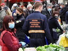 Un operatore della Protezione civile controlla l’uso delle mascherine al mercato ortofrutticolo di Zagabria. jutarnji.hr