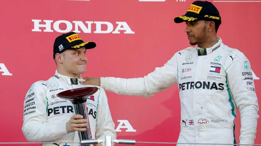 epa07076093 Finnish Formula One driver Valtteri Bottas (L) of Mercedes AMG GP holds his second place trophy next to winner British Formula One driver Lewis Hamilton of Mercedes AMG GP at the end of the Japanese Formula One Grand Prix at the Suzuka Circuit in Suzuka, central Japan, 07 October 2018. EPA/DIEGO AZUBEL