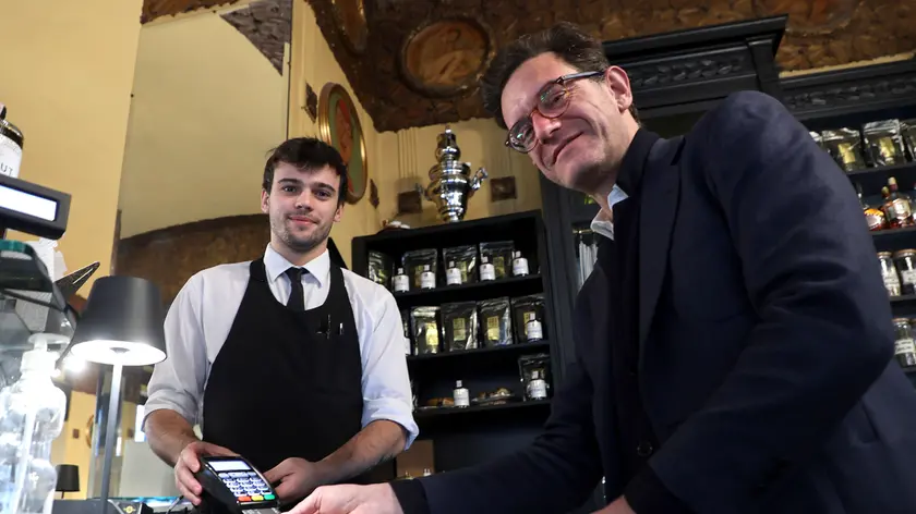 Alexandros Delithanassis, a destra, con il Pos all’interno del Caffè San Marco. Foto di Andrea Lasorte