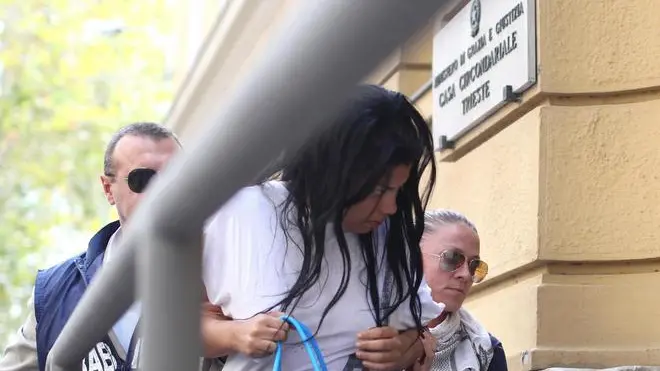 Lisandra Aguila Rica (c), giovane cubana di 21 anni, mentre viene condotta dai Carabinieri nel carcere triestino del Coroneo, Trieste, 17 settembre 2012. Durante l'interrogatorio in caserma a Udine, la giovane fermata ha confessato il duplice omicidio di Lignano ed e' stata arrestata. Lisandra e' accusata di duplice omicidio volontario in concorso con ignoti..ANSA/ANDREA LASORTE