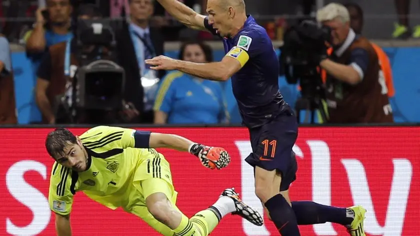 epa04254831 Arjen Robben of the Netherlands on his way to score the 5-1 against goalkeeper Iker Casillas of Spain during the FIFA World Cup 2014 group B preliminary round match between Spain and the Netherlands at the Arena Fonte Nova in Natal, Brazil, 13 June 2014. Daryl Janmaat of the Netherlands on the left. (RESTRICTIONS APPLY: Editorial Use Only, not used in association with any commercial entity - Images must not be used in any form of alert service or push service of any kind including via mobile alert services, downloads to mobile devices or MMS messaging - Images must appear as still images and must not emulate match action video footage - No alteration is made to, and no text or image is superimposed over, any published image which: (a) intentionally obscures or removes a sponsor identification image; or (b) adds or overlays the commercial identification of any third party which is not officially associated with the FIFA World Cup) EPA/KAI FOERSTERLING EDITORIAL USE ONLY EDITORIAL USE ONLY