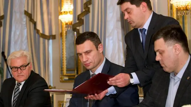 epa04093257 (L-R) German Foreign Minister Frank-Walter Steinmeier, opposition leader Vitali Klitschko and opposition politician Oleg Tjagnibok sign an agreement at the Presidential Palace in Kiev, Ukraine, 21 February 2014. Official in background is not identified. Ukrainian President Viktor Yanukovych and opposition leaders have signed an agreement on a way out of the country's political crisis. A EU delegation with Germany's Fopreign Minister Frank-Walter Steinmeier and Russian negotiator Vladimir Lukin had negotiated with Yanukovitch and opposition leaders all through the night. However Lukin did not sign the agreement in contrast to Steinmeier and Poland's Foreign Minister Radoslaw Sikorski. EPA/TIM BRAKEMEIER