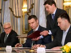 epa04093257 (L-R) German Foreign Minister Frank-Walter Steinmeier, opposition leader Vitali Klitschko and opposition politician Oleg Tjagnibok sign an agreement at the Presidential Palace in Kiev, Ukraine, 21 February 2014. Official in background is not identified. Ukrainian President Viktor Yanukovych and opposition leaders have signed an agreement on a way out of the country's political crisis. A EU delegation with Germany's Fopreign Minister Frank-Walter Steinmeier and Russian negotiator Vladimir Lukin had negotiated with Yanukovitch and opposition leaders all through the night. However Lukin did not sign the agreement in contrast to Steinmeier and Poland's Foreign Minister Radoslaw Sikorski. EPA/TIM BRAKEMEIER