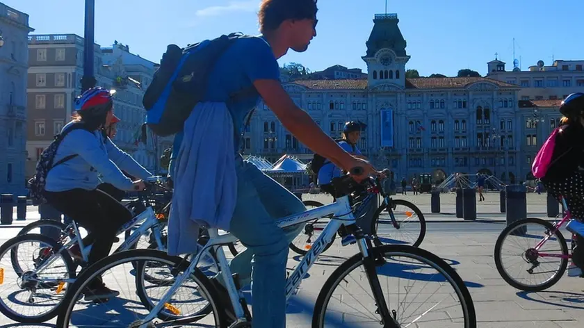 In bicicletta davanti a piazza Unità