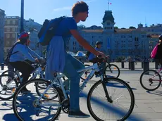 In bicicletta davanti a piazza Unità