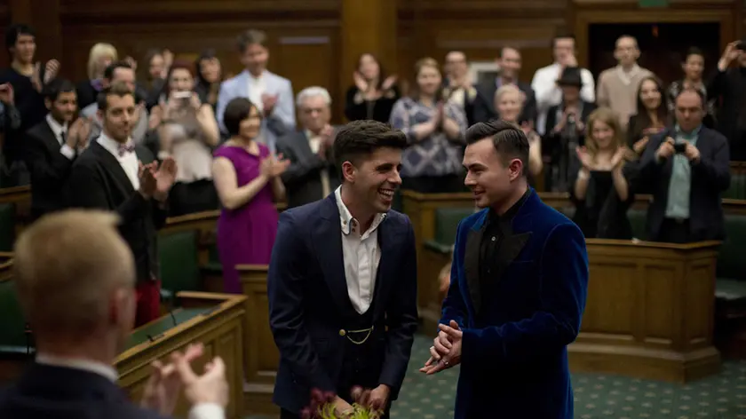 Sean Adl-Tabatabai, left, and Sinclair Treadway are applauded by their guests as they were announced officially married during a wedding ceremony in the Council Chamber at Camden Town Hall in London, minutes into Saturday, March 29, 2014. Gay couples in Britain waited decades for the right to get married. When the opportunity came, some had just days to plan the biggest moment of their lives. Adl-Tabatabai, a 32-year-old TV producer from London, and Treadway, a 20-year-old student originally from Los Angeles, registered their intent to marry on March 13, the first day gay couples could sign up for wedding ceremonies under Britain's new law. Eager to be part of history, the two men picked the earliest possible moment - just after midnight Friday, when the act legalizing same-sex marriage takes effect. (AP Photo/Matt Dunham)