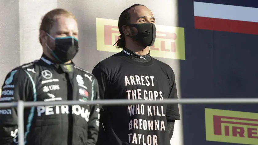 epa08666647 Winner British Formula One driver Lewis Hamilton of Mercedes-AMG Petronas (R) and second Finnish Formula One driver Valtteri Bottas of Mercedes-AMG Petronas (L) react on the podium after the Formula One Grand Prix of Tuscany at the race track in Mugello, Italy 13 September 2020. EPA/Luca Bruno / Pool